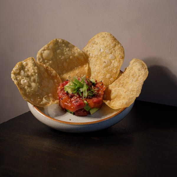 KEI's tuna tartare with avocado, sesame seeds, and scallions, surrounded by crispy wonton chips.